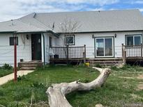 Exterior of a white house with a weathered front yard and a small porch at 15200 Holly St, Thornton, CO 80602
