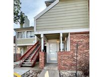 Charming condo entrance features brick accents, covered porch, and stairway to the upper level at 912 S Dearborn Way # 3, Aurora, CO 80012