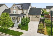 Inviting two-story home featuring a welcoming front porch and solar panels on the roof at 6072 Chester St, Denver, CO 80238