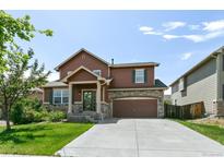 Charming two-story home with a well-manicured lawn and a welcoming front porch at 9919 Memphis St, Commerce City, CO 80022