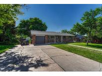 Charming brick home featuring a one-car garage and well-maintained lawn, creating appealing curb appeal at 7479 Pierce St, Arvada, CO 80003