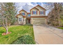 Charming two-story home featuring a well-manicured lawn, mature trees, and an attached two-car garage at 18142 E Oakwood Pl, Aurora, CO 80016
