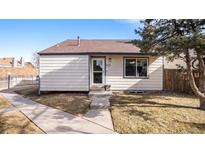Charming single-story home featuring a well-manicured lawn and a welcoming front entrance with concrete walkway at 972 S Zeno Way, Aurora, CO 80017