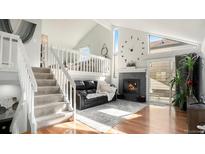 Bright living room with hardwood floors, fireplace, and adjacent loft area for relaxing or entertaining at 972 S Zeno Way, Aurora, CO 80017