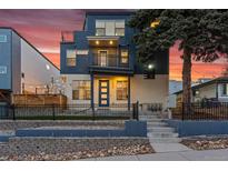 Inviting multi-story home featuring a striking blue and beige exterior and a small front yard with rock landscaping at 1259 Perry St, Denver, CO 80204