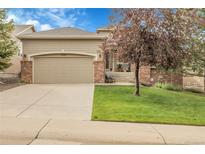 Charming single Gathering home with a manicured lawn, attached garage and inviting curb appeal at 1033 Bramblewood Dr, Castle Pines, CO 80108