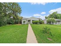 Charming home featuring a well-maintained lawn and inviting walkway leading to the front door at 1909 Iola St, Aurora, CO 80010