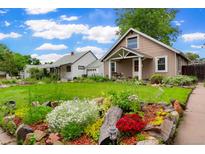 Charming home with a well-maintained lawn and garden beds at 4210 S Fox St, Englewood, CO 80110