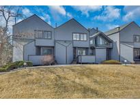 Inviting townhouse featuring a well-manicured lawn and stylish architectural details at 8911 W Yale Ave, Lakewood, CO 80227