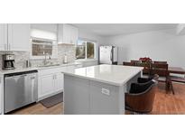 Bright kitchen featuring stainless steel appliances, a center island, and windows for natural light at 23 S Nome St # A, Aurora, CO 80012
