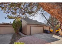 Charming home exterior featuring a two-car garage, mature trees, and inviting landscaping at 7000 W Stetson Pl # 9, Littleton, CO 80123