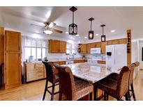 Spacious kitchen with light wood cabinets, stainless appliances, and granite island with seating at 8217 Club Crest Dr, Arvada, CO 80005