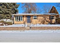 Brick ranch home with snow-covered yard and a spacious driveway at 1000 Collyer St, Longmont, CO 80501