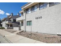 A residential exterior featuring the unit number and low maintenance landscaping and an inviting front porch at 1830 Newland Ct # 101, Lakewood, CO 80214
