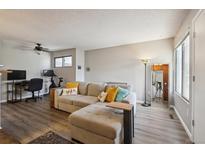 Relaxing living room features a comfortable sectional sofa with accent pillows, and a workspace with desk and chair at 1830 Newland Ct # 101, Lakewood, CO 80214