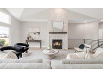 Bright living room features a stone fireplace, high ceilings, and modern decor for a luxurious feel at 14850 Akron St, Brighton, CO 80602
