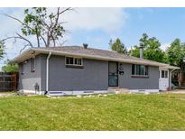 Charming single-story home with a well-maintained lawn, featuring a gray brick facade and cozy curb appeal at 2612 Meadowbrook Dr, Denver, CO 80221