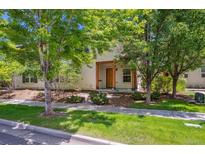 Charming home featuring lush trees, beautiful architectural detail and a well-kept lawn at 2230 Valentia St, Denver, CO 80238