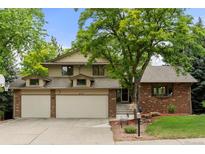 Charming two-story home featuring brick accents, a two-car garage, and mature trees in the front yard at 8571 W 71St Cir, Arvada, CO 80004