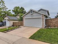 Two-story gray home featuring an attached two-car garage, driveway and well-maintained lawn at 745 Stowe St, Highlands Ranch, CO 80126