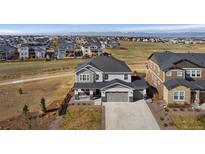 Beautiful two-story home with a three-car garage, manicured lawn, and mountain views at 806 Flora View Dr, Erie, CO 80516