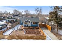 Charming blue home with a cozy front deck, a well-maintained yard, and a private driveway at 131 S Grove St, Denver, CO 80219