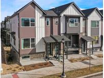 Modern townhome showing its stylish, two-story elevation with covered entryways and balconies, set against a blue sky at 5188 Ward Rd, Wheat Ridge, CO 80033