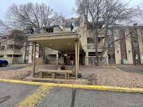 Comfortable apartment building featuring covered entry, well-maintained landscaping, and exterior benches at 1304 S Parker Rd # 346, Denver, CO 80231