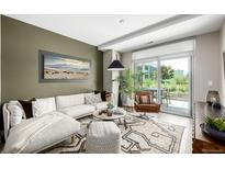 Bright living room with stylish rug, modern sofa, and access to outdoor patio at 4200 W 17Th Ave # 212, Denver, CO 80204