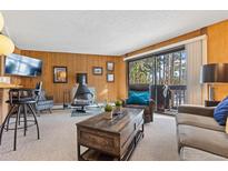 Comfortable living area featuring a unique fireplace and access to a private balcony with scenic views at 1140 Ski Hill Rd # 25, Breckenridge, CO 80424