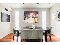 An elegant dining room with rich wood floors, modern decor, and recessed lighting features at 907 E 22Nd Ave, Denver, CO 80205