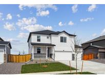 Charming two-story home features a covered porch, attached two-car garage, and a well-maintained lawn at 4115 Marble Dr, Mead, CO 80504