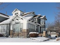 Two-story townhome with snow-covered landscaping and a charming design at 2550 Winding River Dr # M4, Broomfield, CO 80023