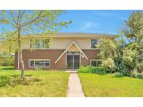 Charming brick and siding home with a well-manicured lawn and inviting entryway at 6484 Kendall St, Arvada, CO 80003
