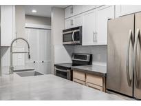 Close-up view of the kitchen showcasing stainless steel appliances and white cabinets at 230 E Highline Cir # 101, Centennial, CO 80122