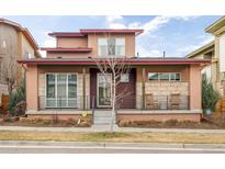 Charming home featuring a cozy front porch with rocking chairs and attractive architectural details at 89 Oneida St, Denver, CO 80230