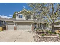 Charming two-story home featuring a large front yard, attached two-car garage, and welcoming front porch at 1153 Berganot Trl, Castle Pines, CO 80108