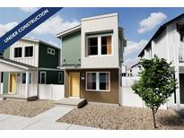 Contemporary two-story home with a yellow front door, gravel landscaping, and neutral exterior color scheme at 13059 E 103Rd Pl, Commerce City, CO 80022