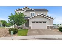 Charming two-story home with neutral siding, stone accents, an attached two car garage, and well manicured yard at 601 Morrison Dr, Frederick, CO 80530
