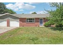 Charming single-story brick home with a well-maintained lawn and attached two-car garage at 4715 Garland St, Wheat Ridge, CO 80033