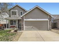 Charming home with a two-car garage and inviting brick-accented entrance at 4222 S Himalaya Way, Aurora, CO 80013