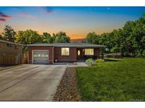 Charming brick home with a well-manicured lawn and an attached one-car garage and beautiful sunset at 7350 W 21St Ave, Lakewood, CO 80214