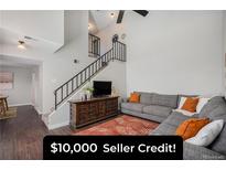 Inviting living room with neutral walls, modern staircase, and stylish decor creates a comfortable and appealing space at 7705 W 87Th Dr, Arvada, CO 80005