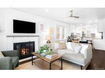 Open-concept living room with a fireplace, neutral decor, and seamless flow to the kitchen at 3139 Chase St, Wheat Ridge, CO 80214