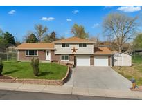Charming two-story home featuring brick accents, a well-maintained lawn, a two car garage and a welcoming facade at 2009 S Zephyr Ct, Lakewood, CO 80227