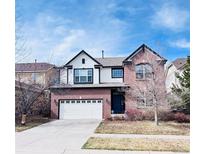 Charming two-story brick home with a well-maintained lawn and a two-car garage at 26032 E Geddes Cir, Aurora, CO 80016