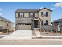 Charming two-story home with stone accents, a spacious two-car garage, and a well-manicured front yard at 1937 S Coolidge Way, Aurora, CO 80018