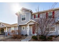 Charming two-story home boasts a gray exterior with red shutters and a welcoming front porch at 5830 Ceylon St # B, Denver, CO 80249