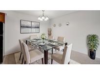 Bright dining room featuring a glass-top table with seating for six, modern lighting, and neutral decor at 7395 E Quincy Ave # 206, Denver, CO 80237