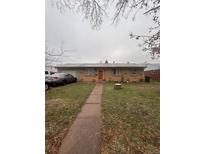 Charming single-story home featuring a brick facade and well-maintained front lawn at 11625 E Alaska Ave, Aurora, CO 80012